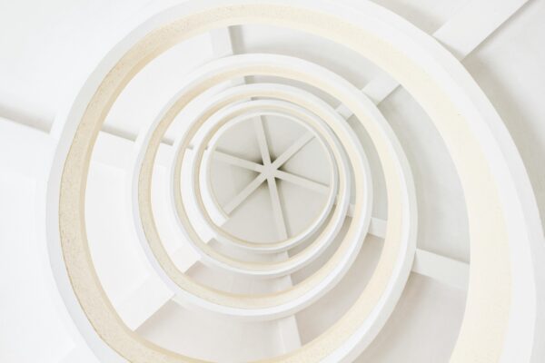 Explore this abstract spiral architecture with a modern minimalist design, featuring geometric white patterns.